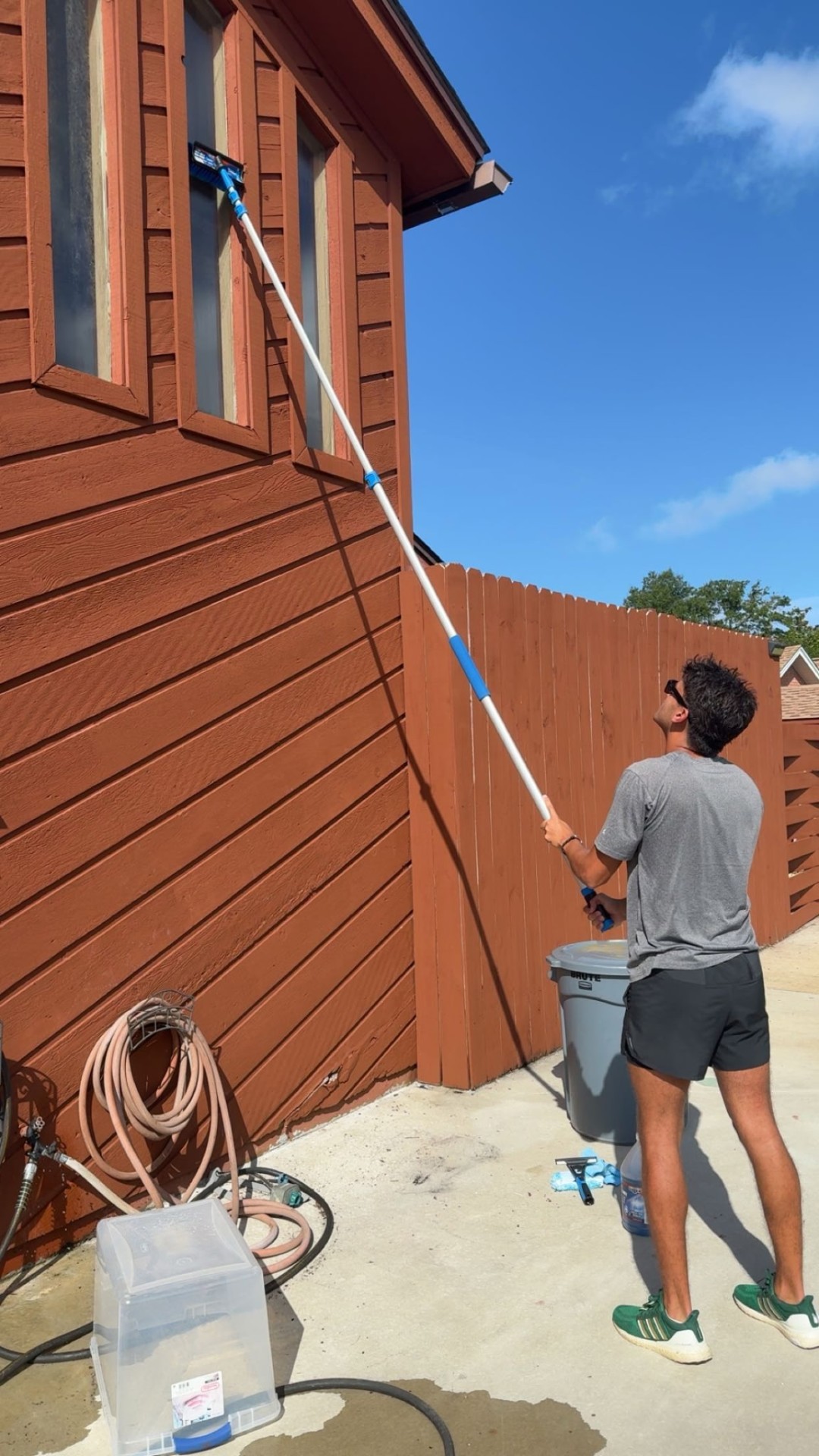 Window Wizards team member cleaning windows with professional water-fed pole equipment