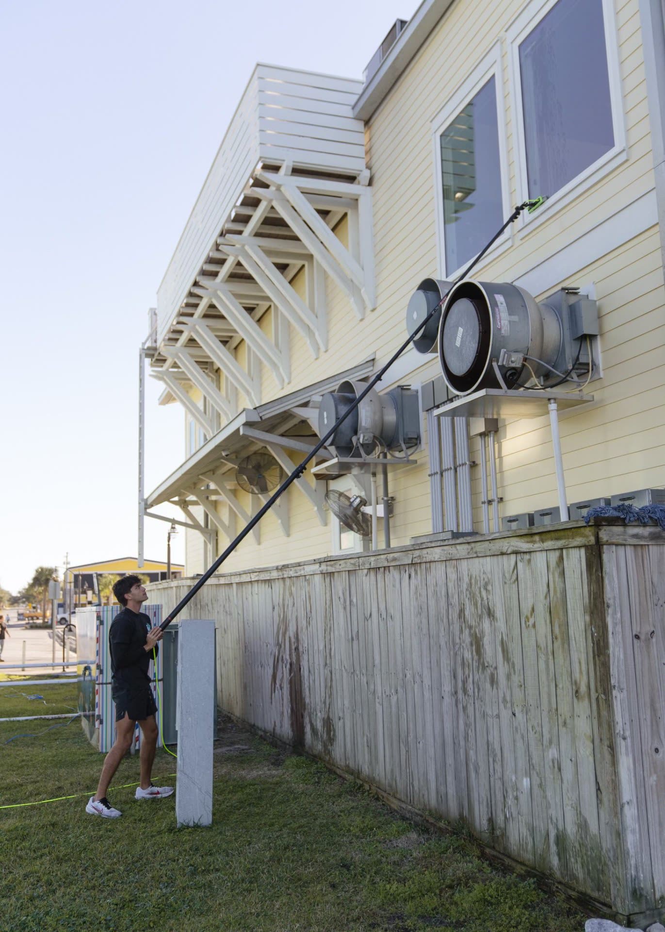 Technician using water-fed pole system on commercial property